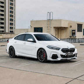 Sporty visual profile transformation of the VTEN gloss black side skirts accenting a Brooklyn Grey 2026 BMW F74