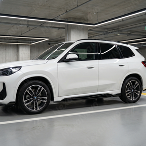 NexaNovo gloss black side skirts providing sharp contrast on a Mineral White BMW X1