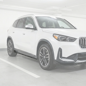 Custom BMW X1 on a showroom floor featuring NexaNovo side skirt upgrades