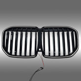 NexaNovo gloss black single-piece LED illuminated grille glowing on a 2023 BMW X7 G07
