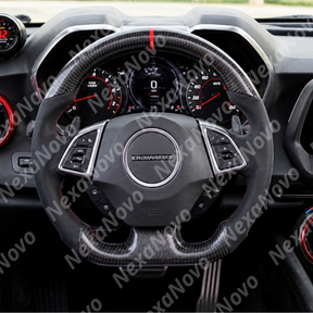 Wide-angle interior shot displaying the gloss carbon and suede-style wheel complementing the Camaro muscle car center console