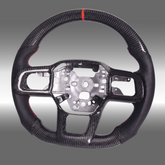 Custom 3K gloss carbon fiber sport steering wheel with perforated leather and red center stripe installed in a 2024-2027 Ford Mustang S650 cockpit