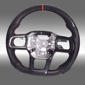 Custom 3K gloss carbon fiber sport steering wheel with perforated leather and red center stripe installed in a 2024-2027 Ford Mustang S650 cockpit