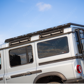 Hard-shell overland rooftop tent securely mounted to the NexaNovo platform on a 2026 Grenadier