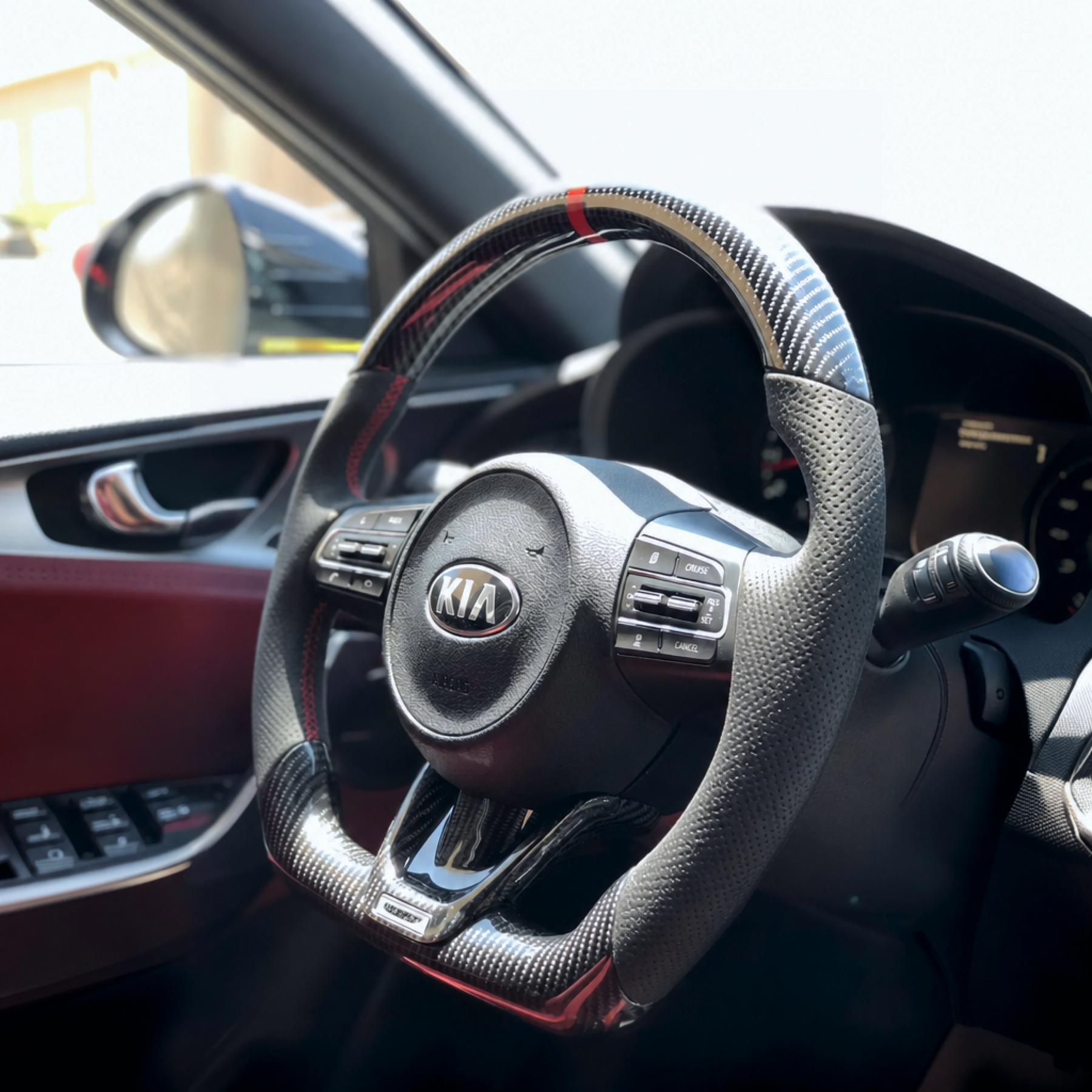 Wide-angle interior shot displaying the gloss carbon fiber wheel integrating with the Stinger center console