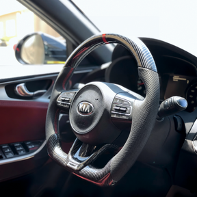 Wide-angle interior shot displaying the gloss carbon fiber wheel integrating with the Stinger center console
