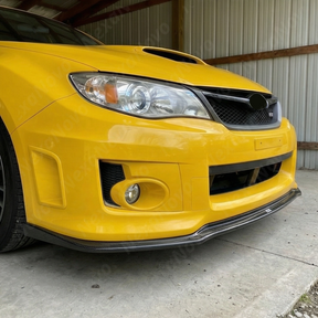 Front-end shot emphasizing the widened, aggressive track stance of the STI with NexaNovo aero
