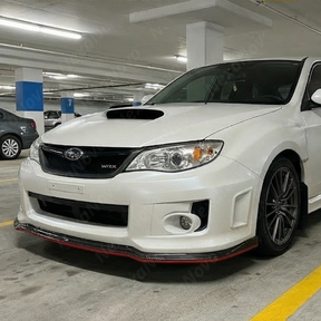 Full 3/4 view of a 2012 Subaru WRX STI with the red-accented carbon fiber print front lip kit