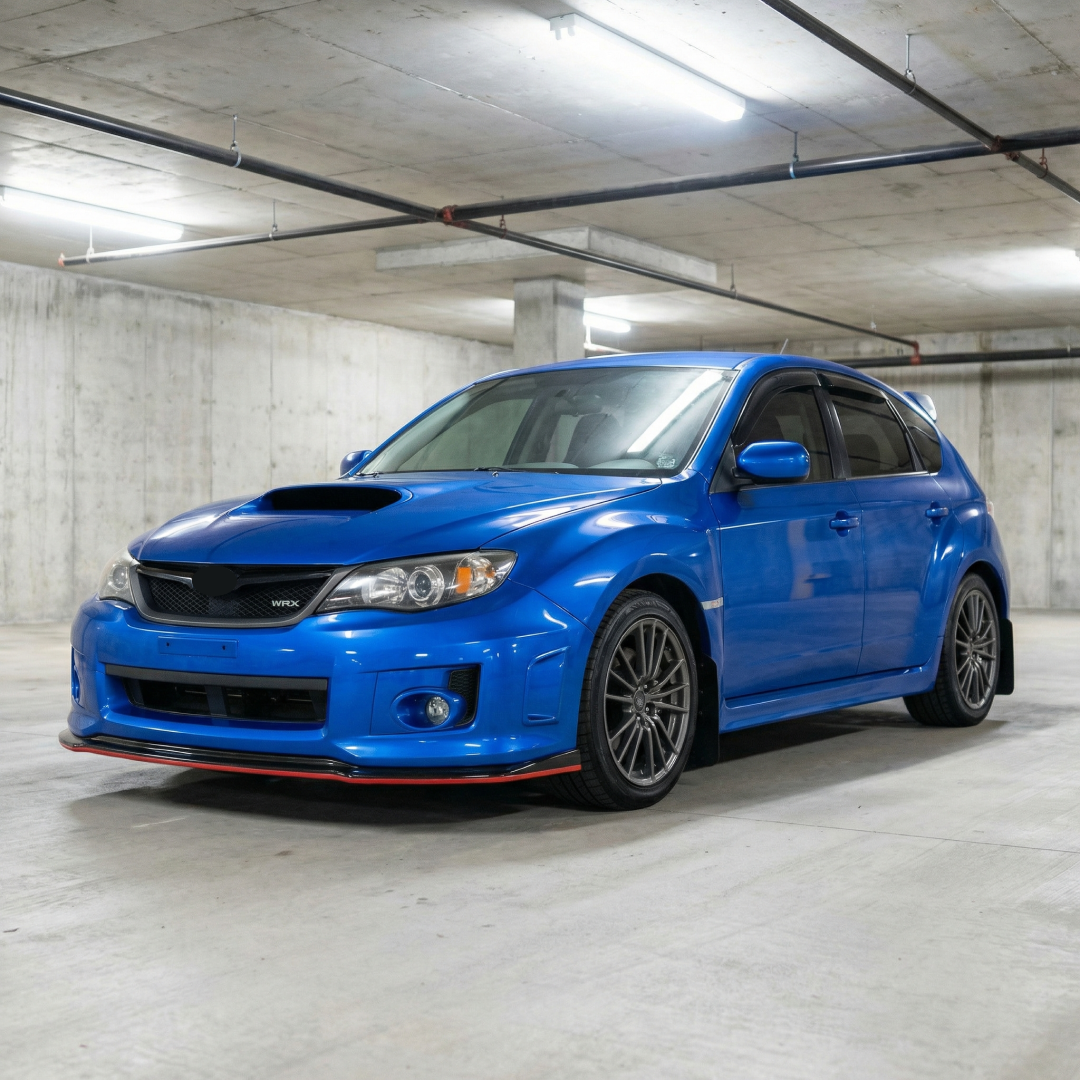 Gloss black front splitter lip with red accent trim installed on a 2011 Subaru Impreza WRX STI