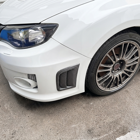 Sporty carbon fiber print vents providing a race-inspired look on a Satin White Pearl Subaru STI