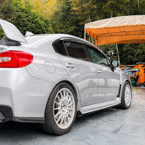 Low-angle perspective highlighting the sleek, ground-hugging profile of the gloss black JDM extensions