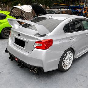 Gloss black rear diffuser fins providing aggressive contrast on a World Rally Blue Subaru STI