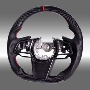 Custom 3K gloss carbon fiber sport steering wheel with perforated leather and red center stripe installed in a 2022-2027 Subaru WRX cockpit