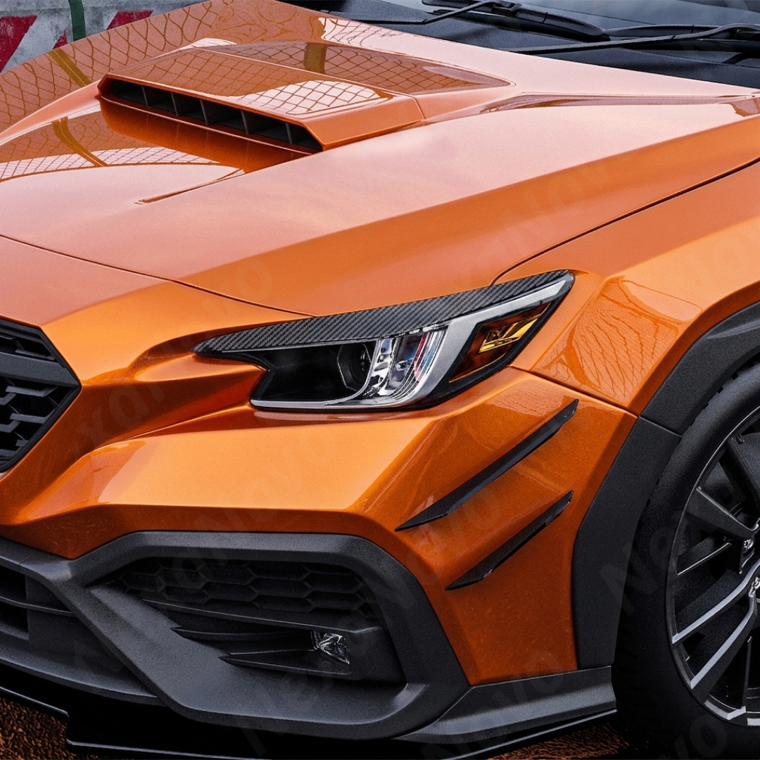 Sporty carbon fiber print eyelids providing a race-inspired look on a Solar Orange Pearl Subaru WRX