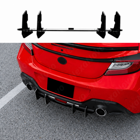 Gloss black V-style diffuser fins providing a sharp, aggressive contrast on an Ignition Red Toyota GR86.